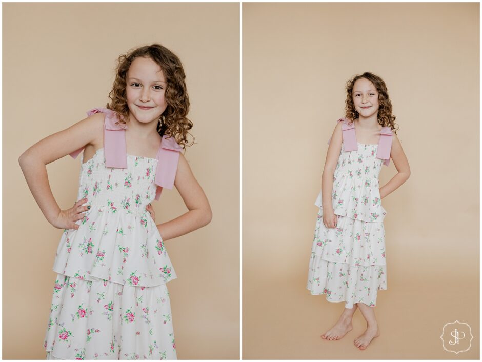 little girl standing on a tan backdrop posing for her birthday photos