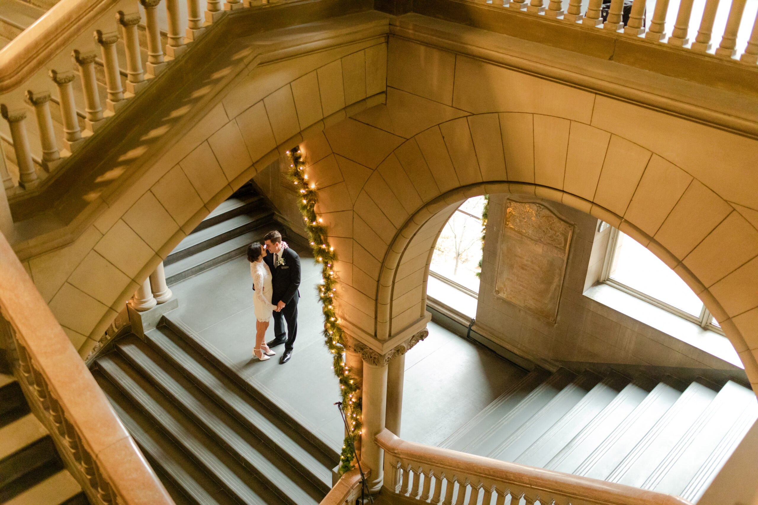 Allegheny Country Courthouse elopement with the bride and groom snuggled up under the arches of the architecture.